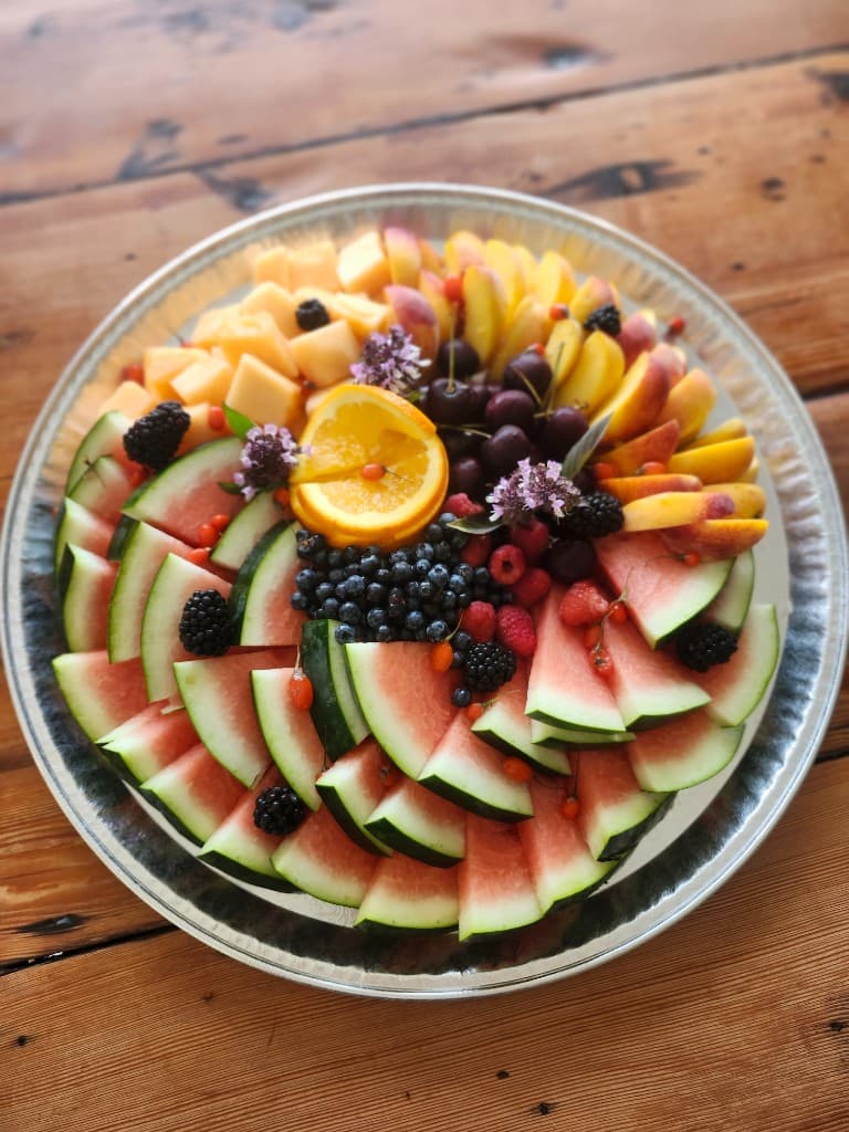 Catering fruit tray with watermelon, melon, peaches, and berries